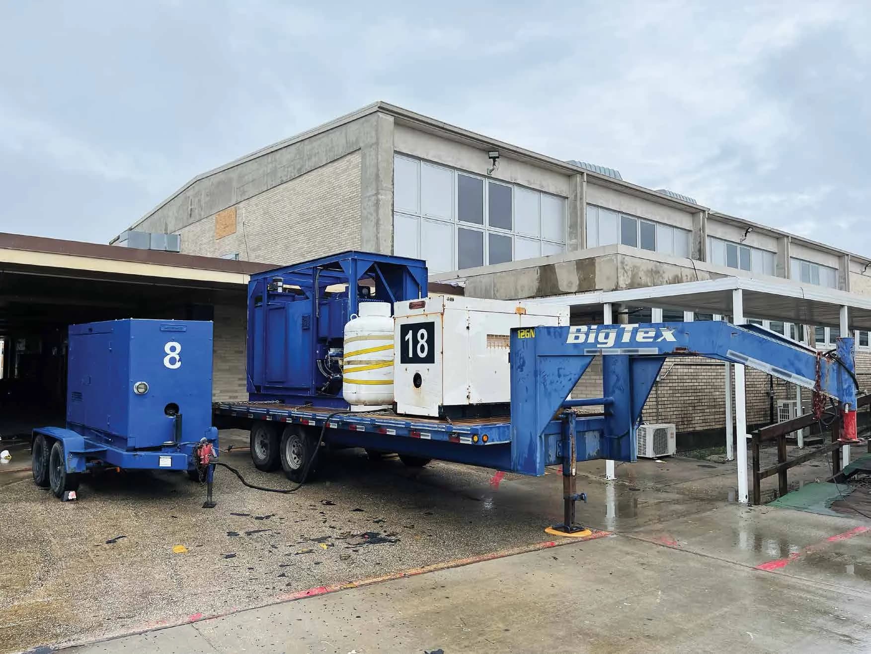 Generators and drying equipment on trailers outside an industrial building
